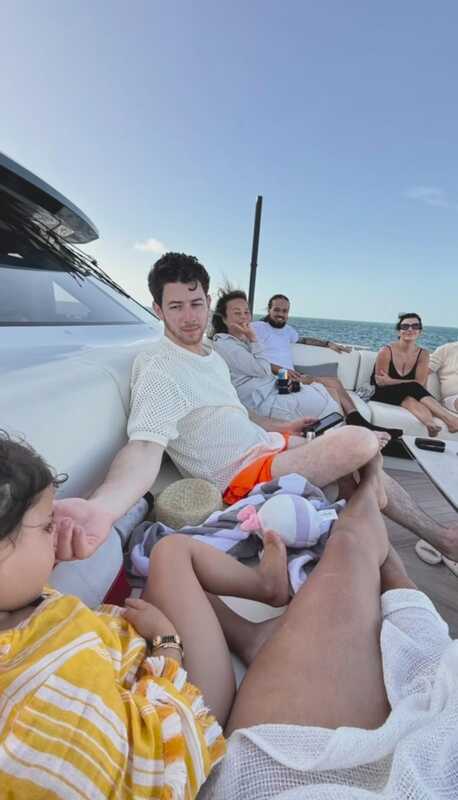 The Jonas family sits together and enjoys a cruise ride as Nick Jonas plays with baby Malti Marie, sitting beside Priyanka. 